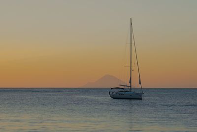 Sailboat sailing on sea against sky during sunset