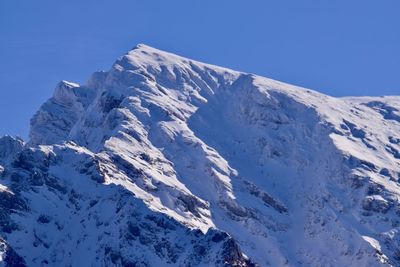 Scenic view of snowcapped mountains against clear blue sky