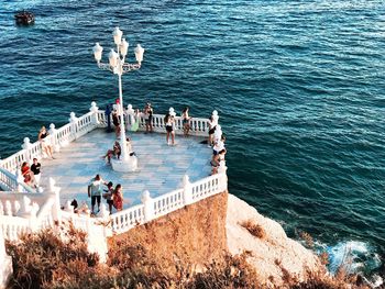 High angle view of people on rock by sea