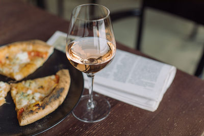 Close-up of wineglass with pizza on table