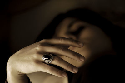 Cropped image of woman holding hands over black background