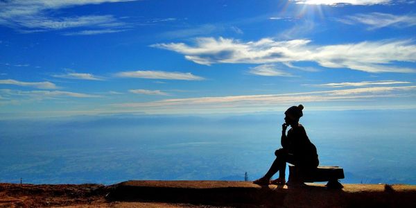 Side view of man sitting on bench