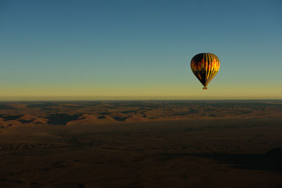 Hot air balloon flying over desert