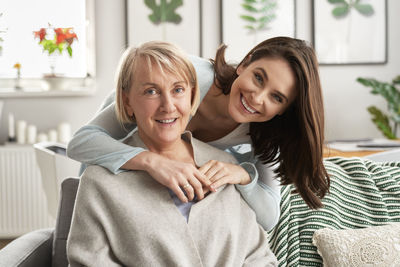 Portrait of young woman sitting on bed at home