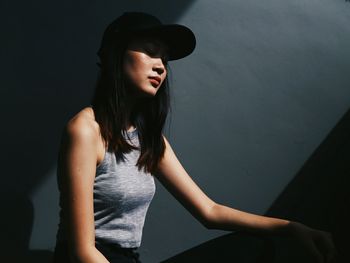 Fashion model standing against wall