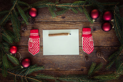 Close-up of christmas decorations with blank paper on pencil on table