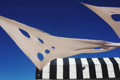 Low angle view of flag against clear blue sky