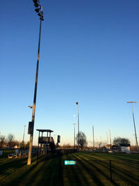 Trees on field against clear blue sky