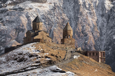 Panoramic view of historic building against mountain during winter