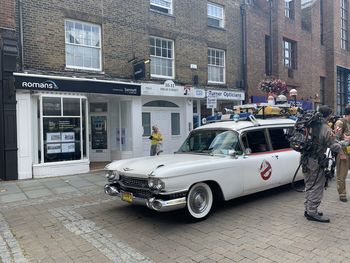 Vintage car on street against buildings in city