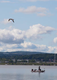 Scenic view of birds flying over water against sky