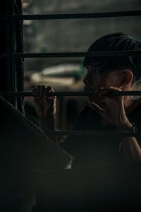 Portrait of young man holding window