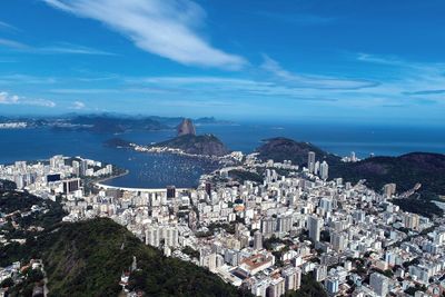 High angle view of townscape by sea against sky