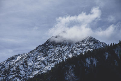 Low angle view of snowcapped mountains against sky