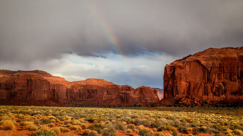 Scenic view of rainbow over landscape against sky