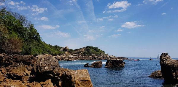 Rock formations in sea against sky