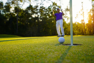 Low section of man playing golf on field