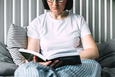 Young woman sitting on sofa at home