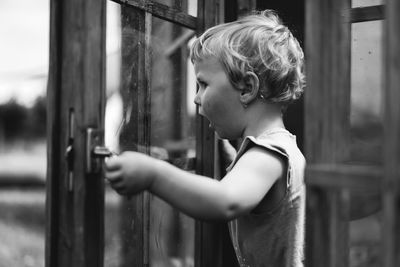 Portrait of baby girl playing in wooden house