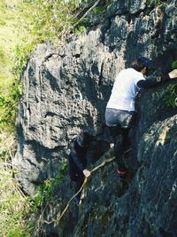 Rear view of man on rock by mountain