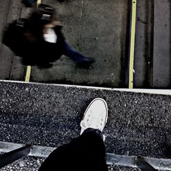 Low section of man standing on road