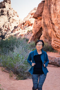 Portrait of senior asian woman hiking in the desert landscape