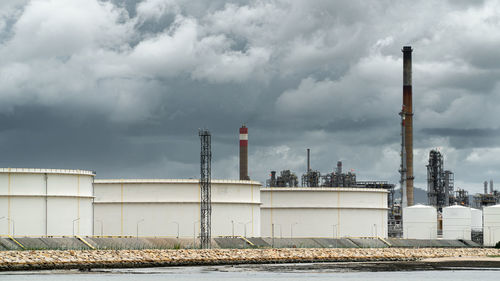 Smoke emitting from factory against sky