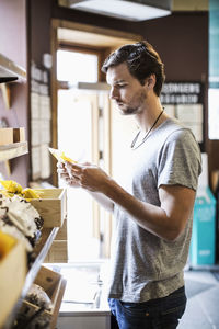 Young man reading label in grocery store