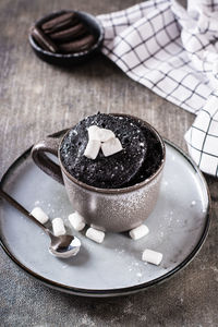 Quick chocolate cake mug with marshmallows on a plate on the table vertical view