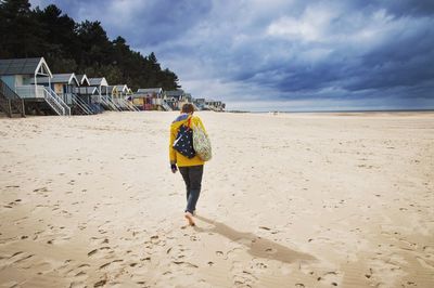 Rear view of man walking on beach