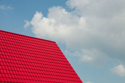 Low angle view of house roof against cloudy sky