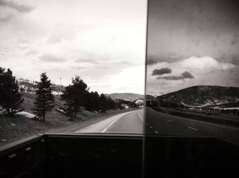 Road passing through landscape against cloudy sky