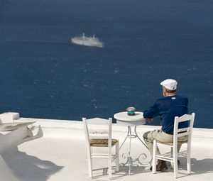 Man watching cruise ship sailing in sea