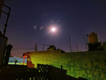 Low angle view of illuminated city against sky during sunset