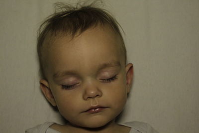 Close-up of baby sleeping on bed