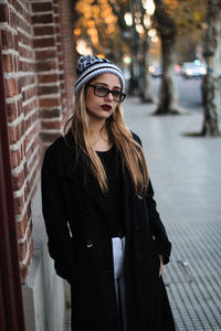 Portrait of young woman standing on street