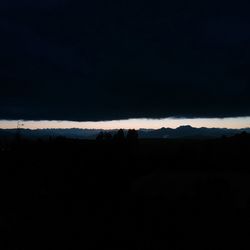 Silhouette landscape against sky at night