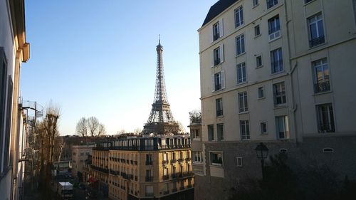 Eiffel tower and residential buildings against clear blue sky