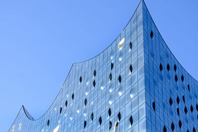 Low angle view of modern building against blue sky