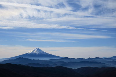 Scenic view of snowcapped mountains against cloudy sky