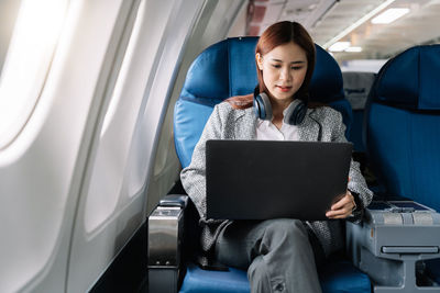 Young woman using laptop while sitting in car