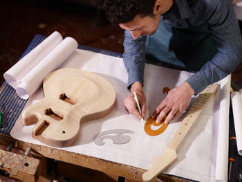 High angle view of man drawing over paper