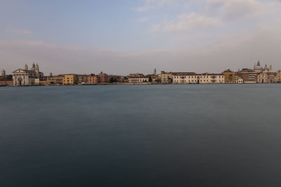 View of buildings in city against cloudy sky