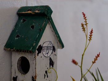 Low angle view of old birdhouse on wall