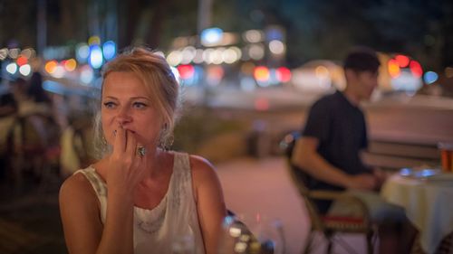 Thoughtful woman sitting in cafe at night