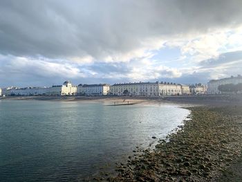 View of river by buildings against sky