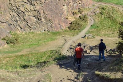 Rear view of men walking on mountain