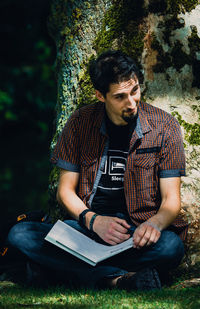 Young man sitting on book