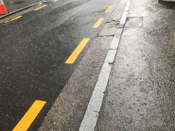 High angle view of arrow symbol on rainy road 