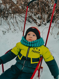 Low angle view of boy standing on snow covered field